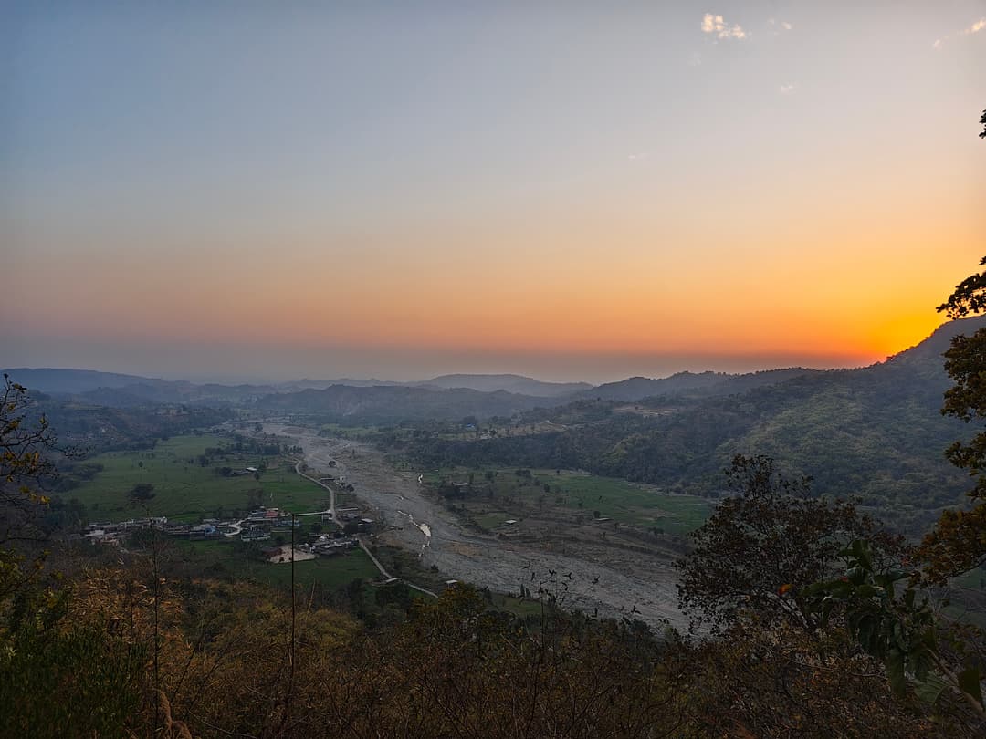 A person paragliding over a valley.